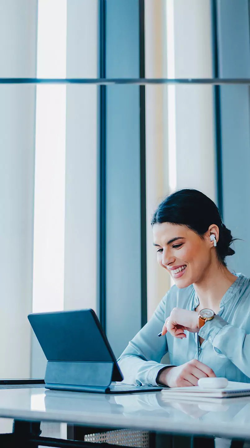 A woman training online in front of a 2-in-1 laptop