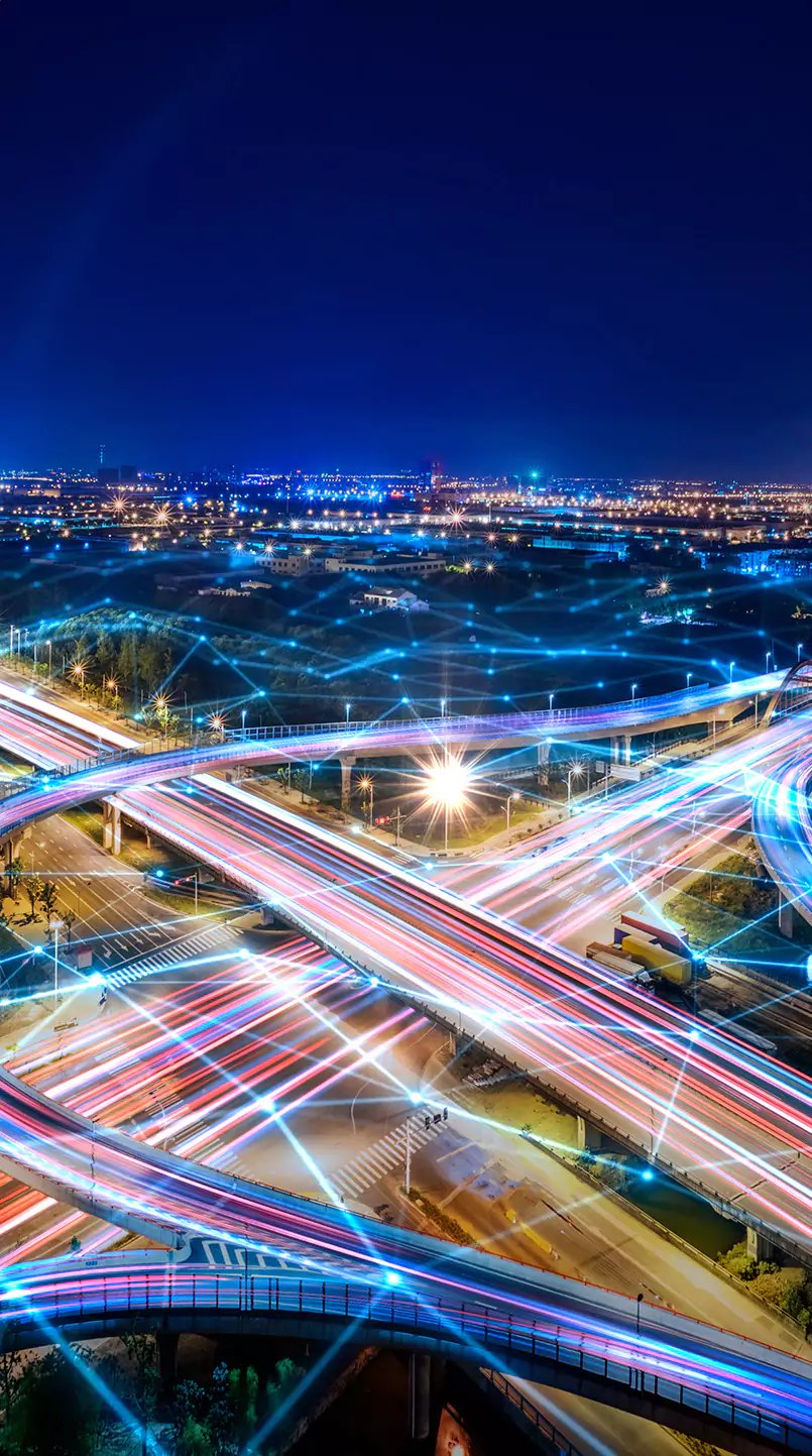 Eine moderne Stadt bei Nacht mit beeindruckenden Lichtern. Das Bild wird überlagert von digitalen Vernetzungsstrukturen.