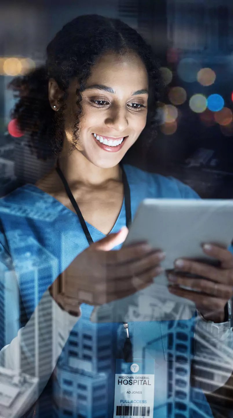 Eine Mitarbeiterin im Krankenhaus blickt zufrieden auf den digitalen Dienstplan auf einem Tablet.